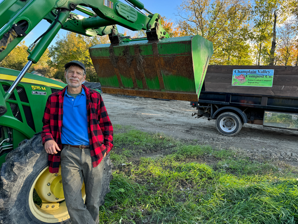 Steve Wisbaum leaning against his John Deere tractor